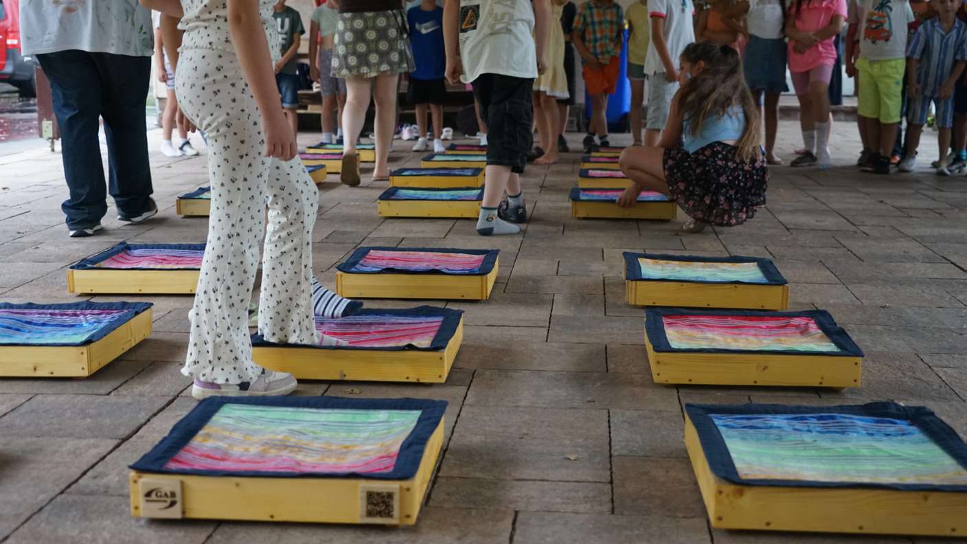 35353394-mit-den-fuessen-galt-es-den-inhalt-der-kaestchen-zu-ertasten-die-grundschueler-der-zweiten-klassen-probieren-das-spiel-des-projektes-passt-aus-2o7a